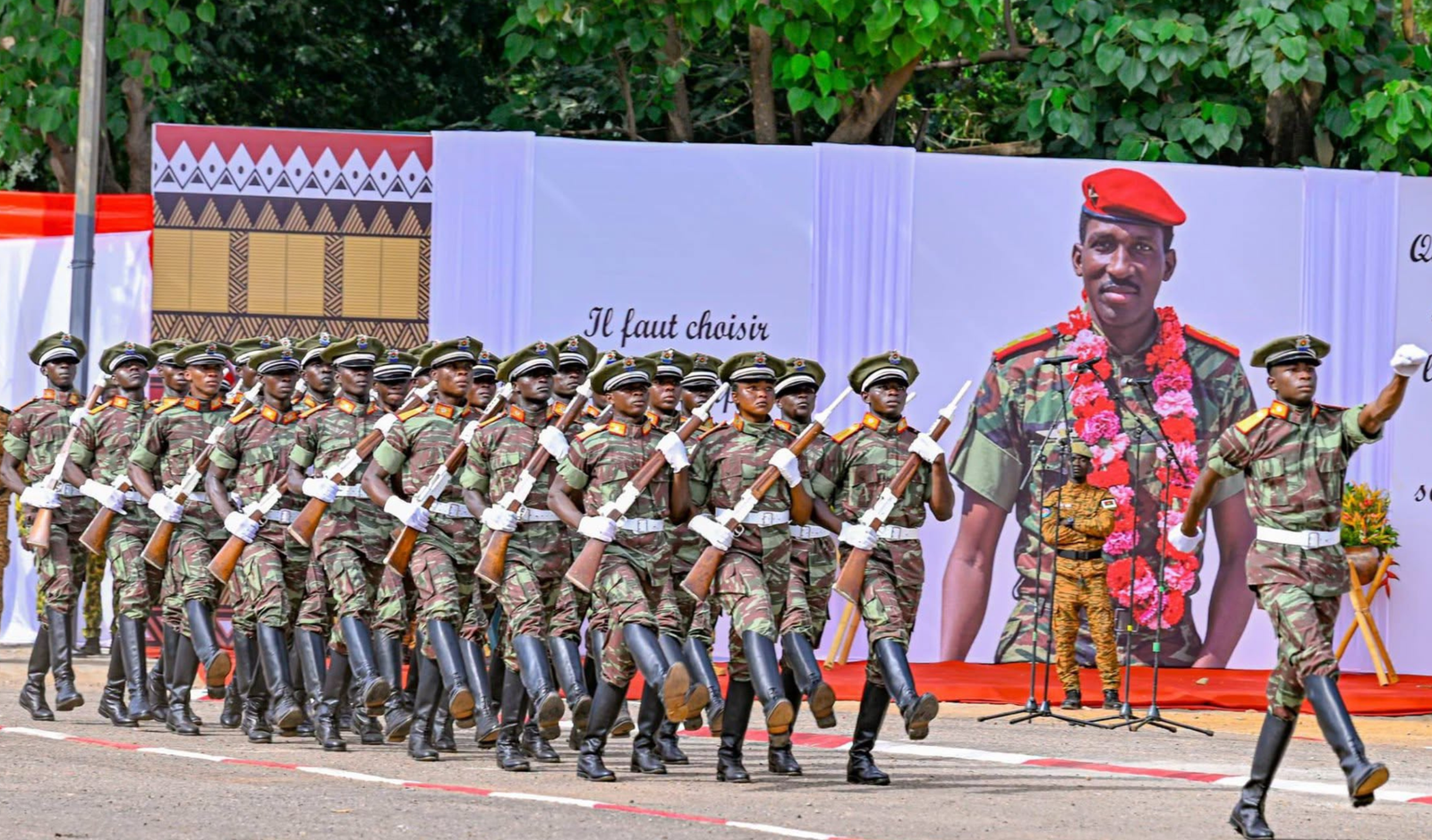 Soldats burkinabè alignés devant la fresque hommage au Capitaine Thomas Sankara avec sa citation historique contre l'impérialisme.